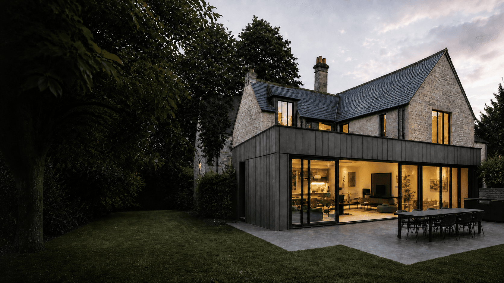 Modern extension to a traditional stone farmhouse at dusk